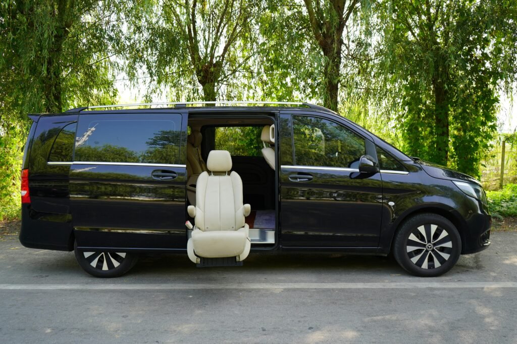 A luxurious black van with an elegant leather seat exposed outdoors, highlighting accessibility and comfort.