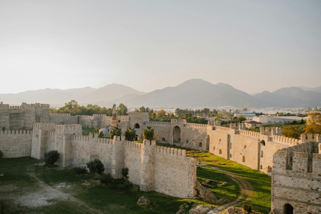 Stunning aerial view of historical fortress walls with mountains in Alanya, Turkey.